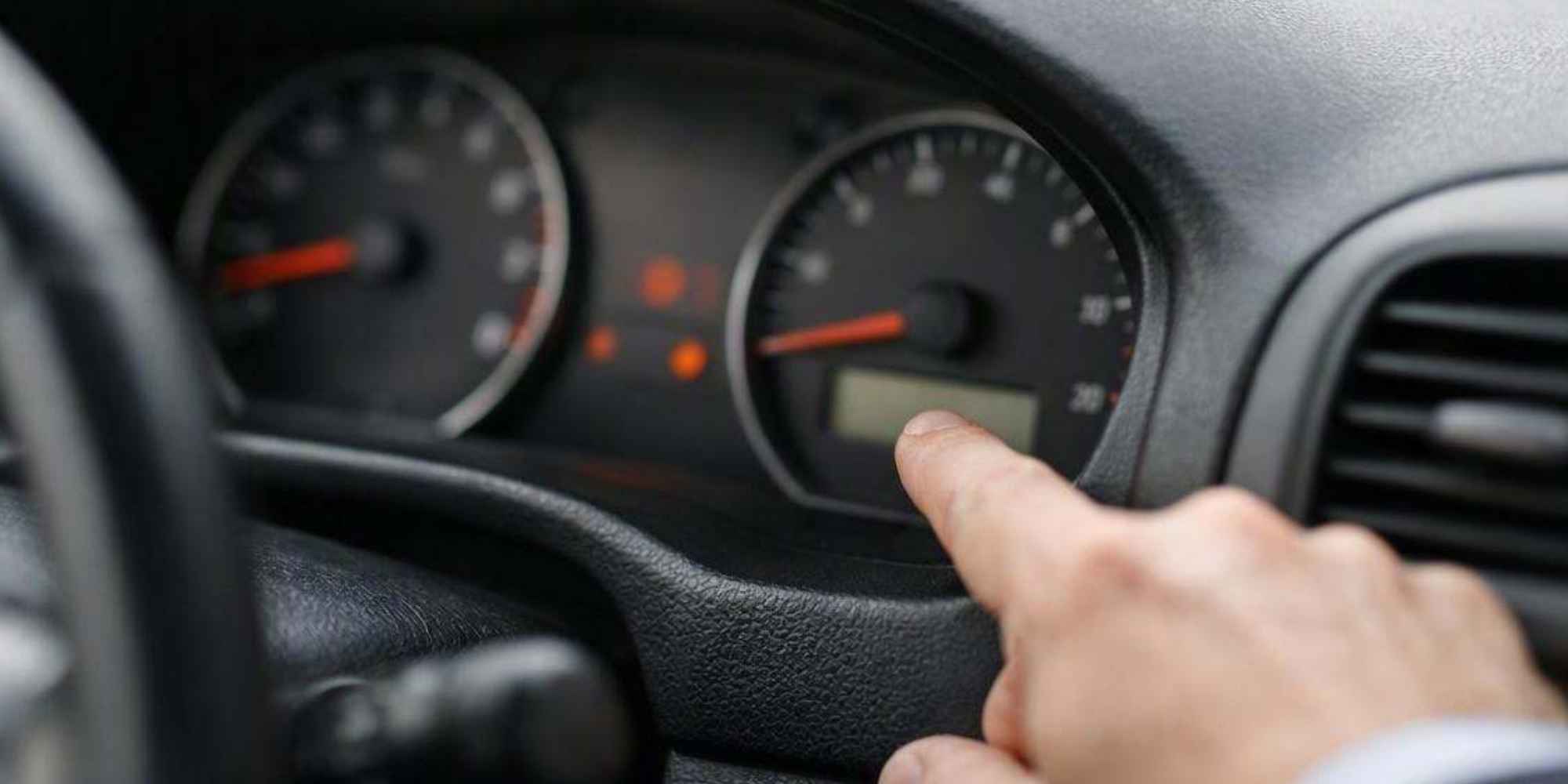 Persona señalando el cuentakilómetros de un coche de segunda mano para comprobar su kilometraje