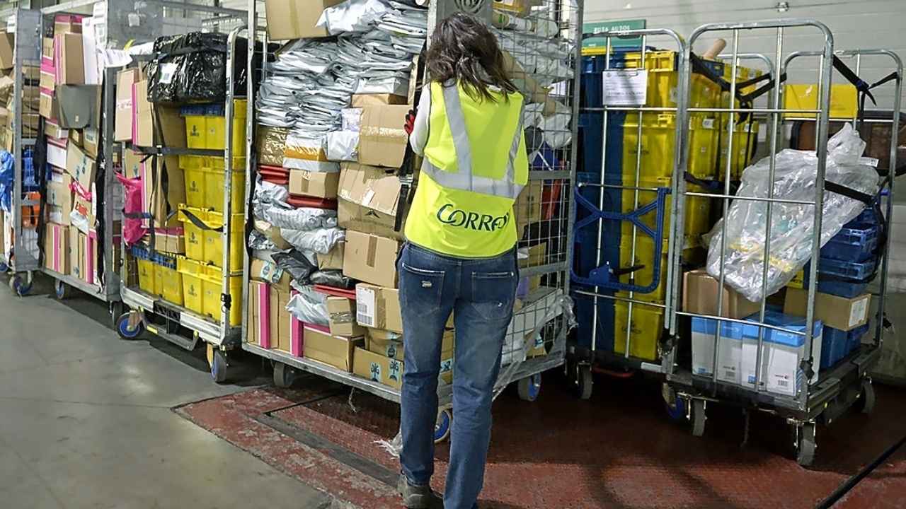 Persona clasificando paquetes en el interior de un centro logístico.