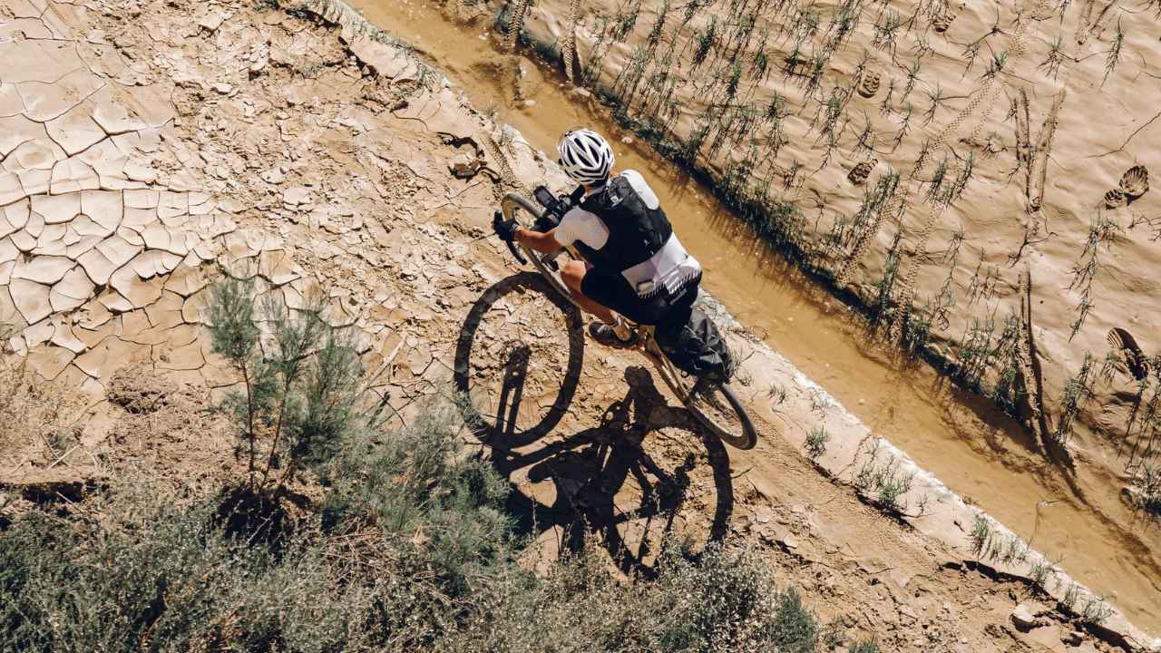 Ciclista practicando ciclismo de montaña por un terreno irregular