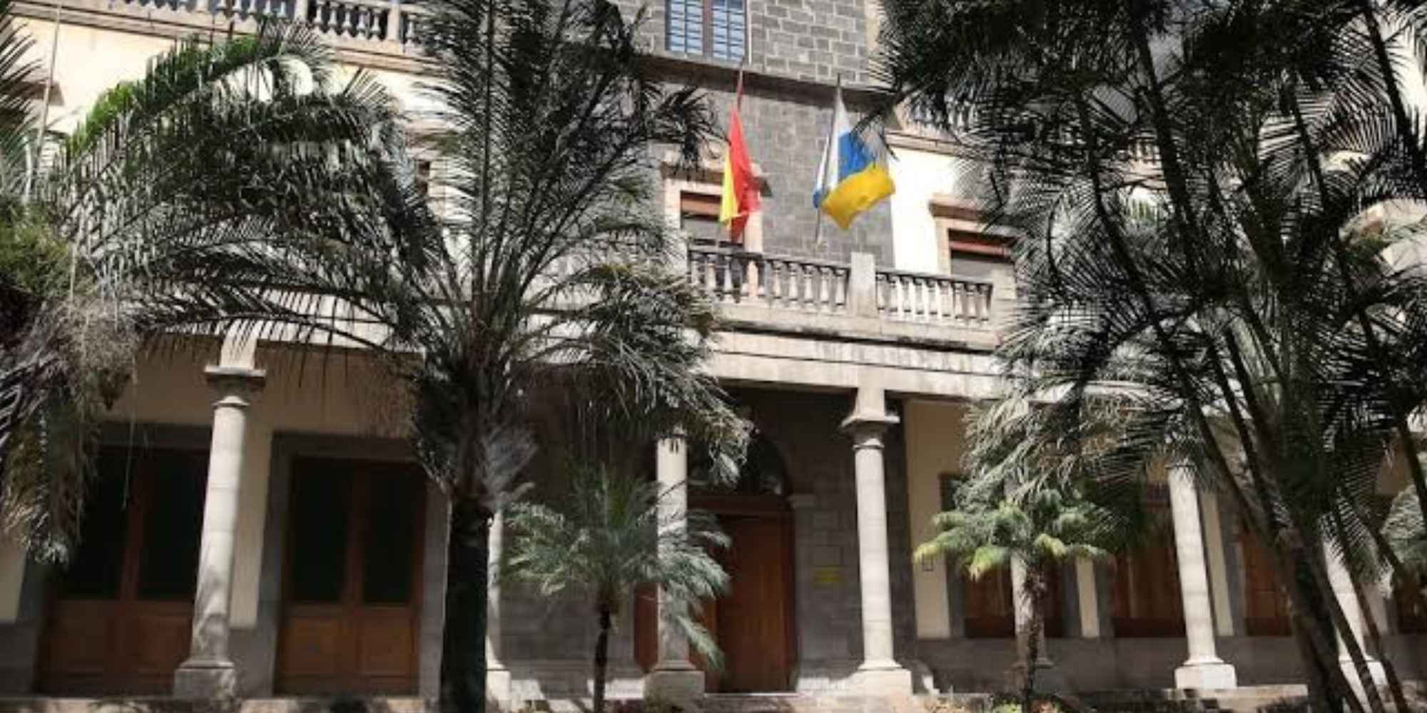 Fachada de un edificio institucional con banderas de España y Canarias, relacionada con una sentencia judicial sobre despido laboral. Copiar