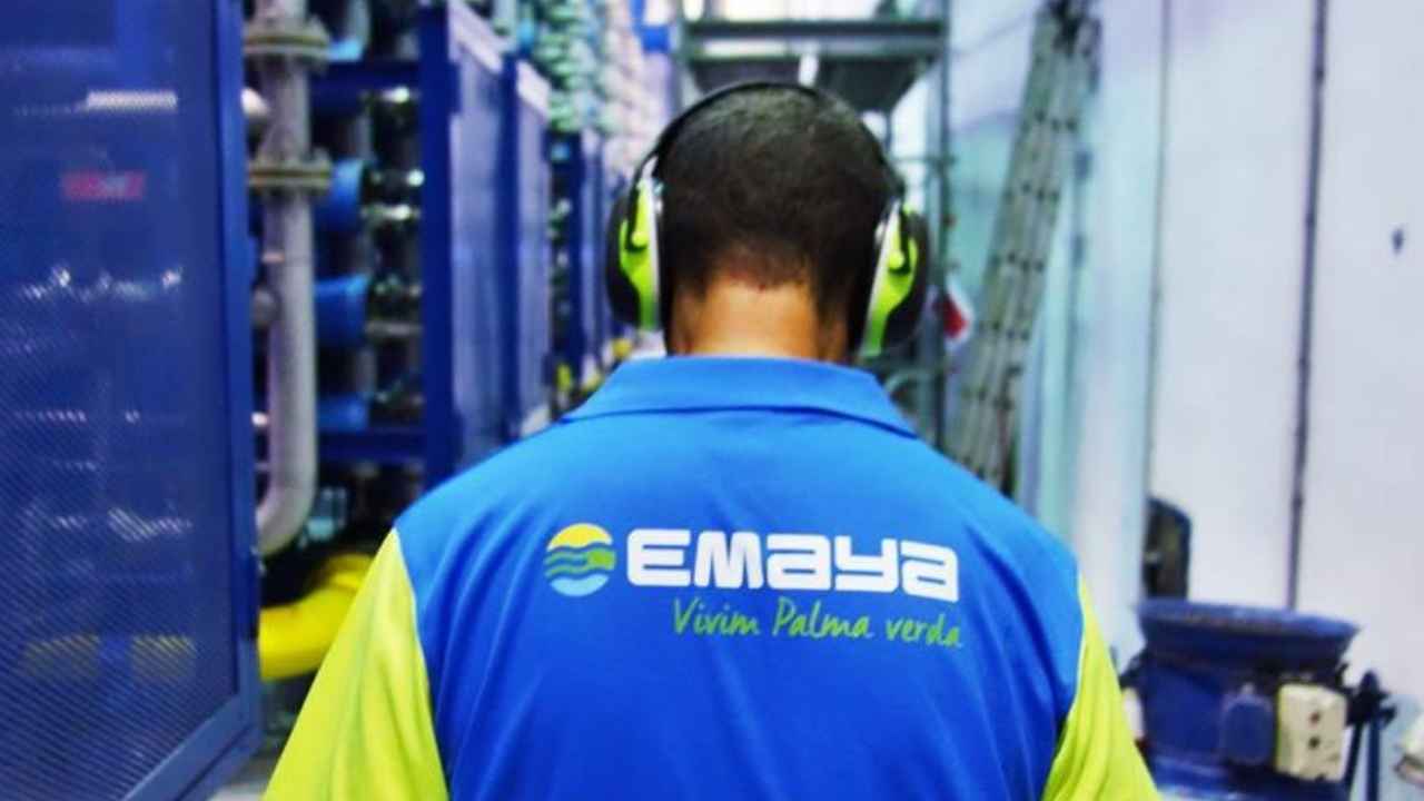 Trabajador de Emaya con uniforme azul y amarillo y protectores auditivos en el interior de unas instalaciones industriales.