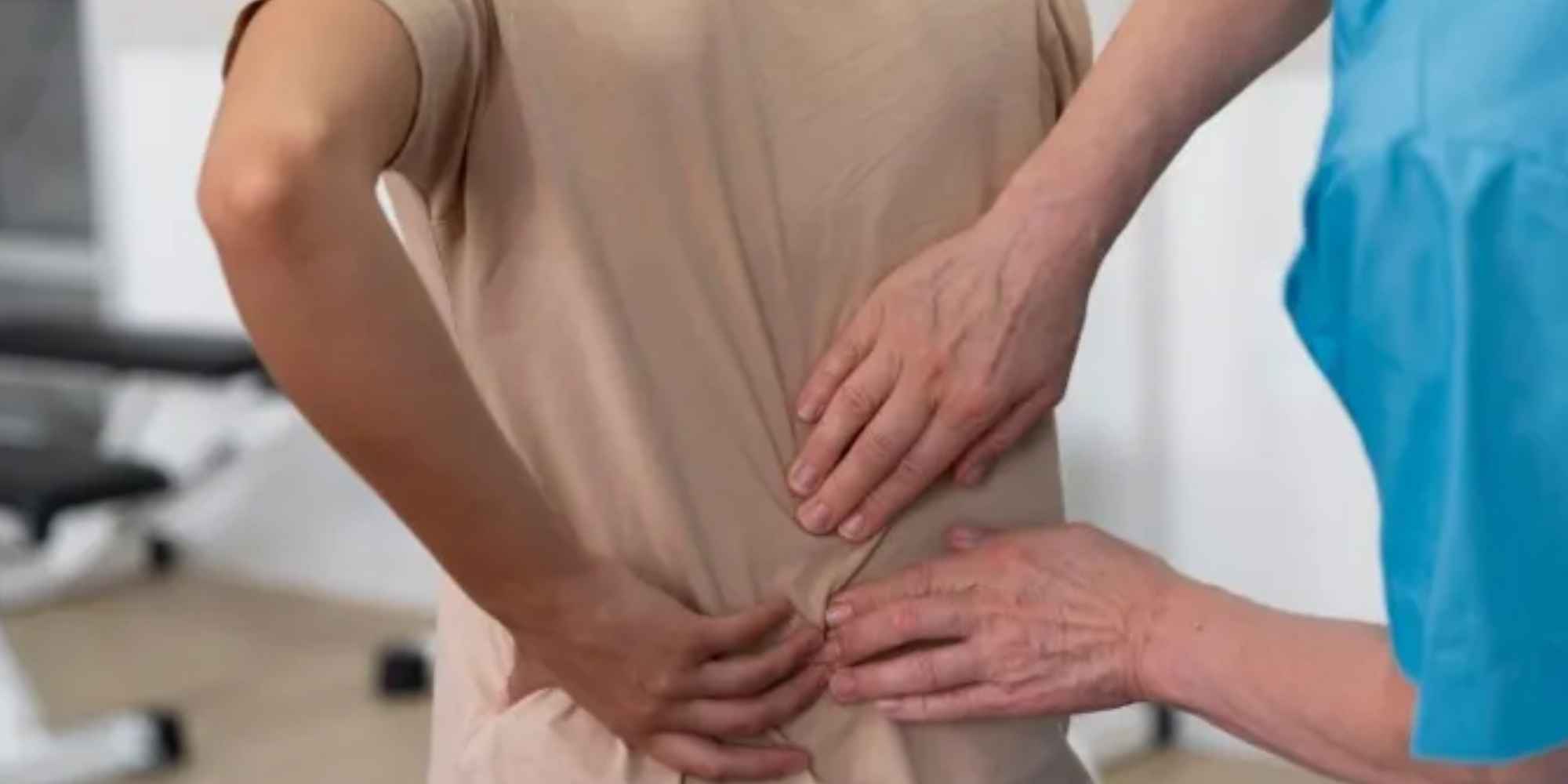 Persona con dolor lumbar durante una exploración médica de la espalda por un profesional sanitario. Copiar