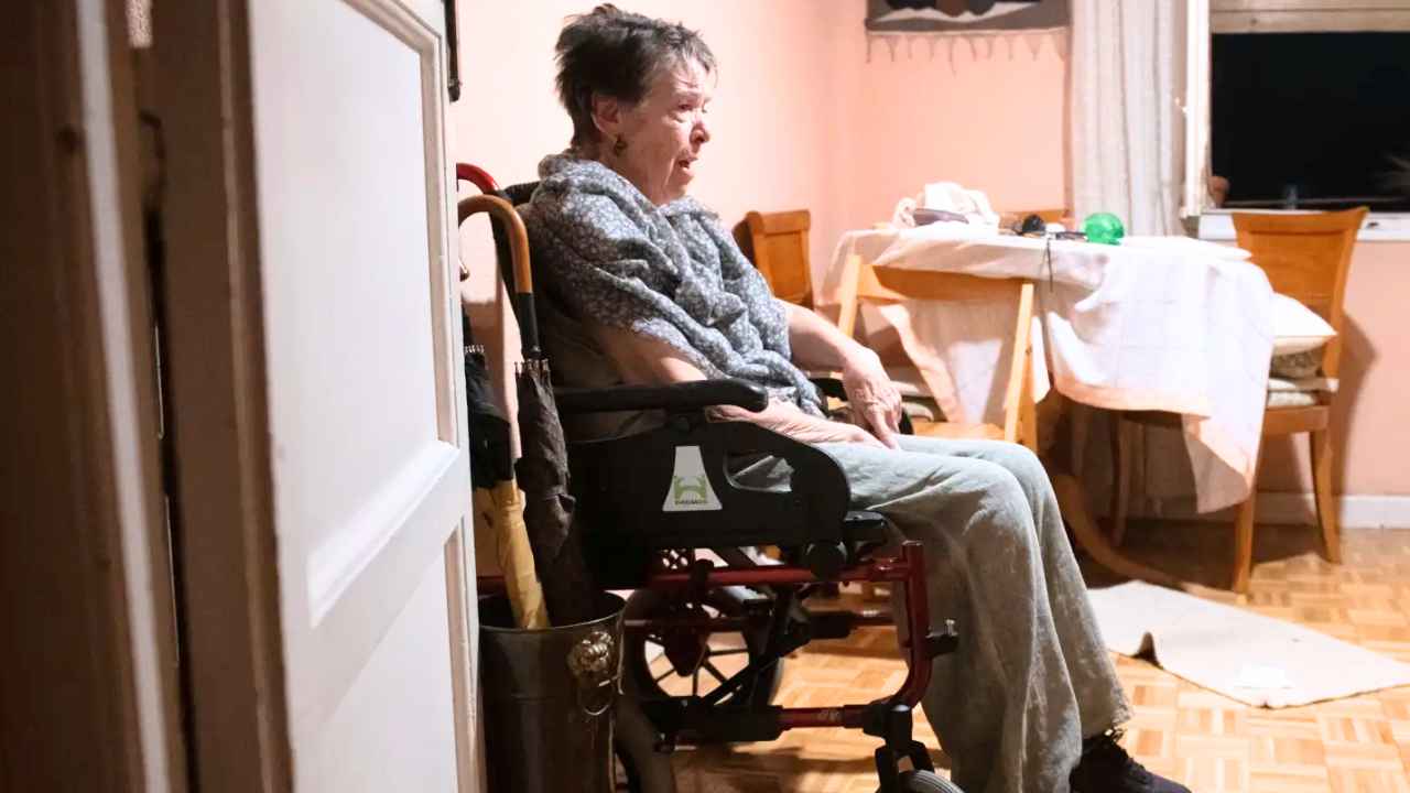 Mujer mayor en silla de ruedas en el interior de una vivienda