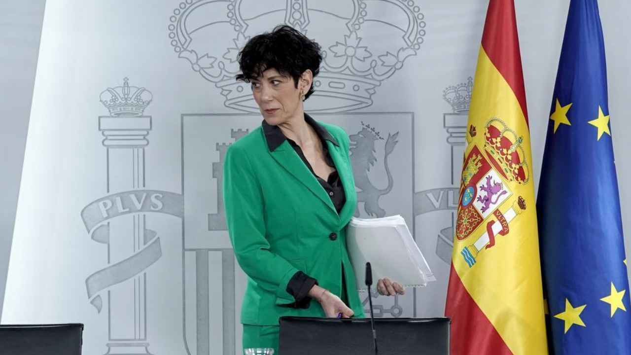 Representante del Gobierno de España durante una comparecencia oficial junto a las banderas española y europea.