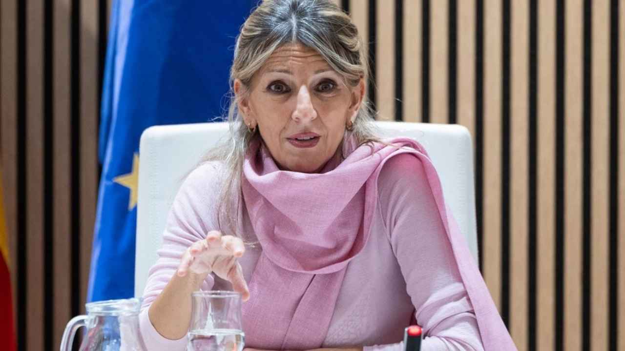 Yolanda Díaz interviene sentada ante un micrófono, con la bandera de la Unión Europea al fondo.